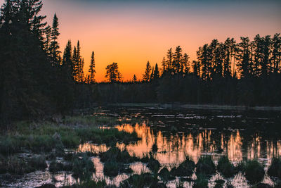 Scenic view of lake against sky at sunset