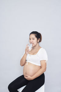 Portrait of a young woman against white background