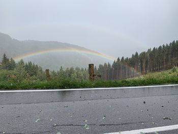 Scenic view of rainbow over road against sky