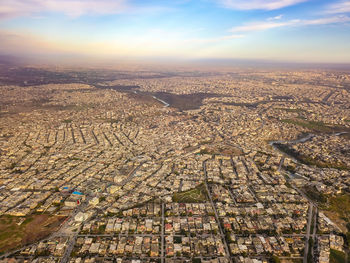 High angle view of city buildings against cloudy sky