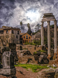 View of buildings in city against cloudy sky