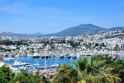 Scenic view of sea and mountains against clear blue sky