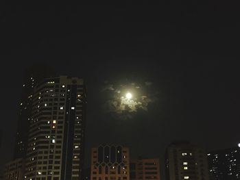 Low angle view of illuminated buildings against sky at night