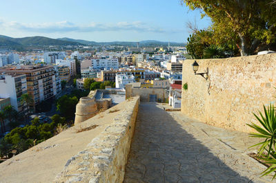 View of cityscape by sea against sky