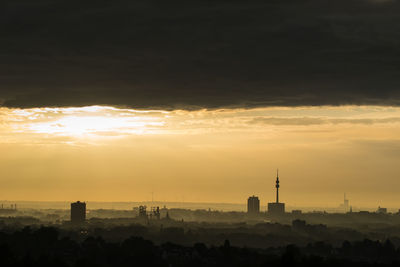 Silhouette buildings against sky during sunset