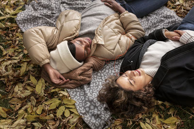 Female friends relaxing on blanket at autumn