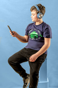 Full length of boy using mobile phone