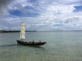 Sailboat sailing on sea against sky