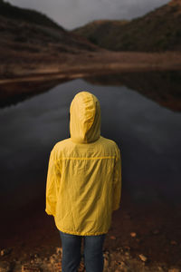 Rear view of man standing on riverbank