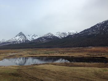 Scenic view of lake and snowcapped mountains against sky