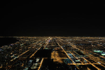 Illuminated cityscape against clear sky at night