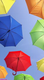 Low angle view of multi colored umbrellas against sky