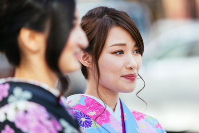 Smiling women wearing traditional clothing standing on road in city