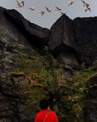 Rear view of man on cliff against sky