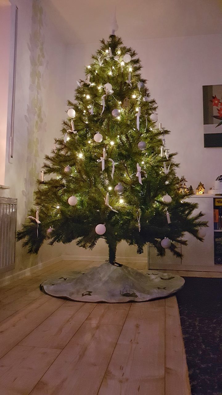 ILLUMINATED CHRISTMAS TREE ON FLOOR AT HOME