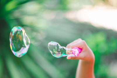 Close-up of hand making bubbles with wand