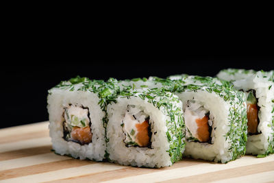 Close-up of sushi on table against black background