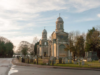 Church by building against sky in city