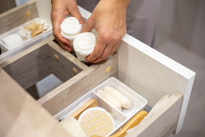 Cropped hand of woman holding napkins in drawer