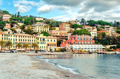 View of city by sea against sky