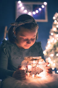 Close-up of girl playing with christmas decoration