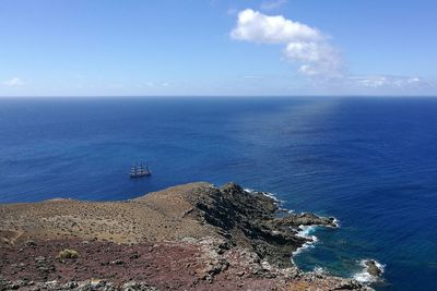Boats sailing in calm blue sea against sky
