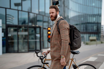 Businessman walking with bicycle on road