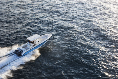 Aerial view of couple driving speedboat on sea