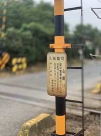 Close-up of information sign on pole in city