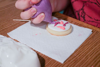 High angle view of hand holding ice cream on table