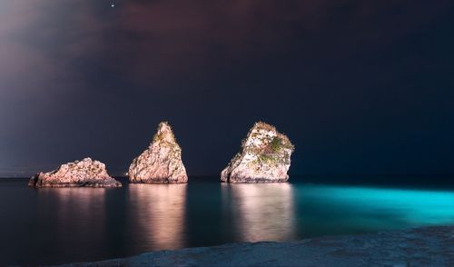 View of rock formation in sea against sky