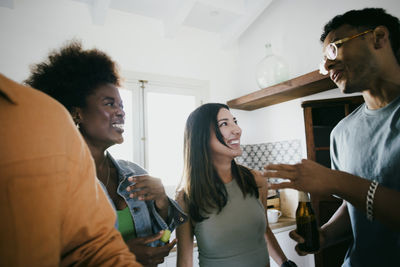 Happy multiracial talking during dinner party at home