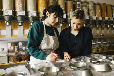 Multiracial female colleagues taking inventory in food store