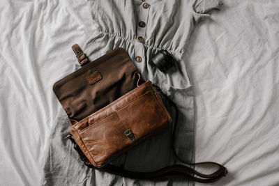 Directly above shot of leather bag and dress on sheet