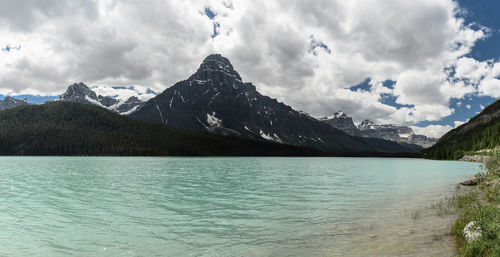 Scenic view of mountains and lake against cloudy sky