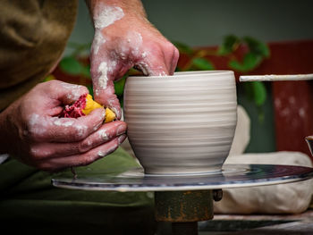 Cropped hands making pot