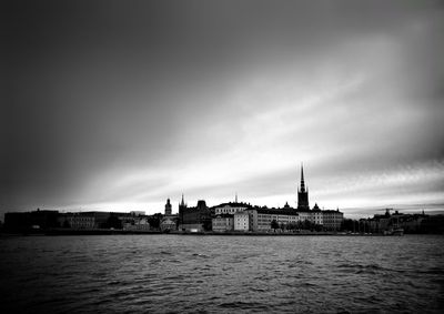 View of buildings in city against cloudy sky