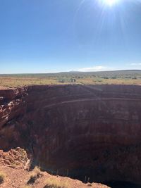 Scenic view of landscape against sky on sunny day