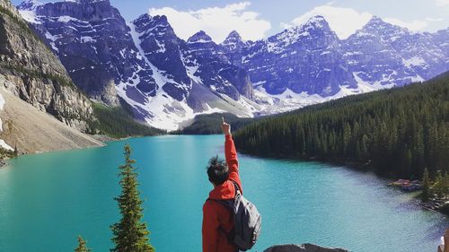 Person by lake against mountain range