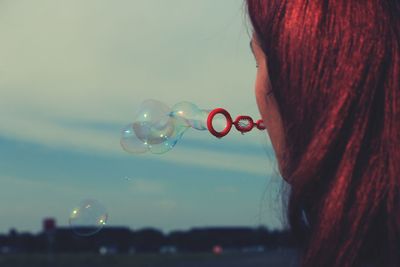 Close-up of woman blowing bubbles outdors