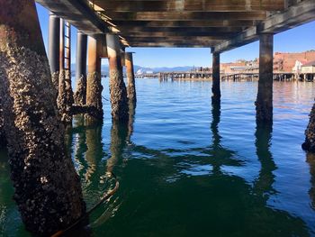 Wooden pier on river against sky