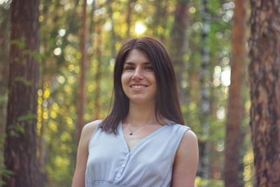 Portrait of a smiling young woman in forest