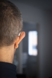 Rear view of man looking at camera