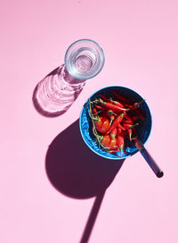 Studio shot of bowl of red chili peppers and glass of water