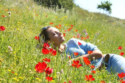 Close-up of young woman relaxing on field