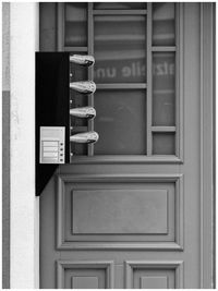 Close-up of closed door with newspaper and post 