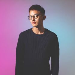 Young man standing against gray background