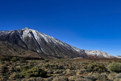 Scenic view of mountains against clear blue sky