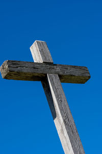 Low angle view of cross against clear blue sky