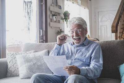 Portrait of senior man sitting on sofa at home